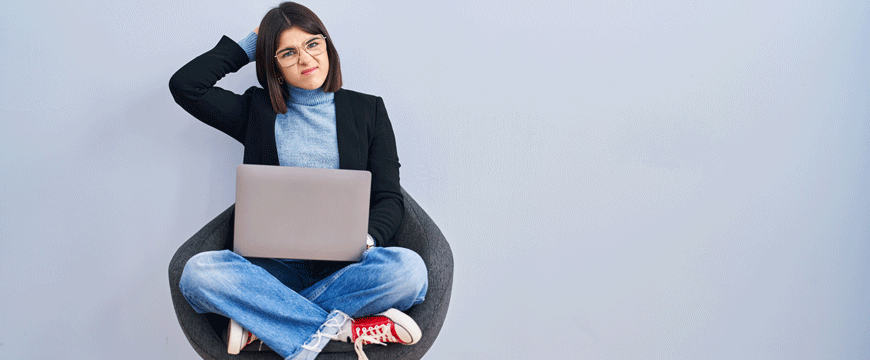 Girl Sitting in a Chair with a Computer, Confused