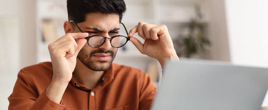 Man Looking at a Computer in Confusion