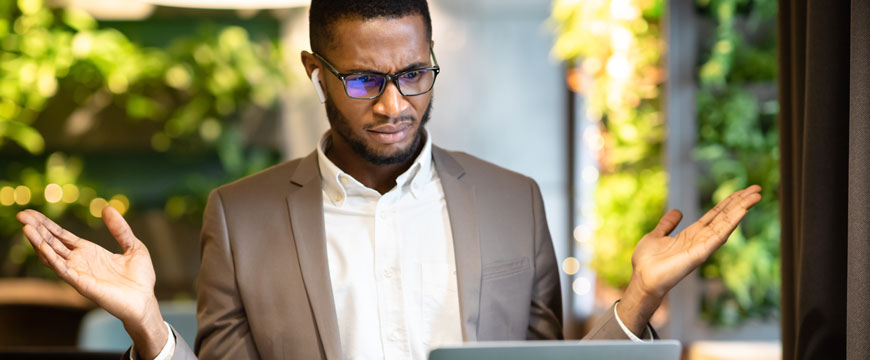 Man Looking at a Computer in Confusion