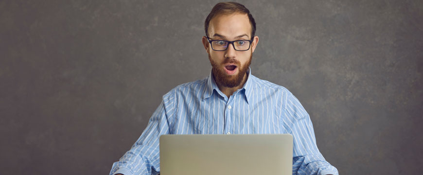 Guy Looking at Computer in Shock