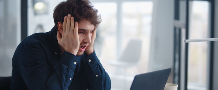 Person Looking at Computer in Shock