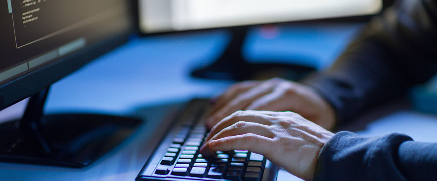 Person Typing on a Computer with Malicious Software Coding