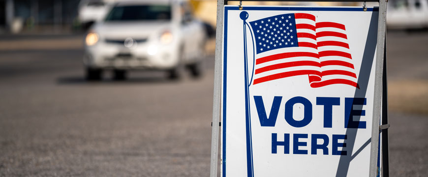 "Vote Here" Sign with Car in Background